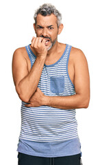 Wall Mural - Middle age grey-haired man wearing casual style with sleeveless shirt looking stressed and nervous with hands on mouth biting nails. anxiety problem.