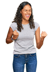 Wall Mural - Young african american girl wearing casual clothes celebrating surprised and amazed for success with arms raised and eyes closed. winner concept.