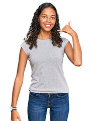 Wall Mural - Young african american girl wearing casual clothes smiling doing phone gesture with hand and fingers like talking on the telephone. communicating concepts.
