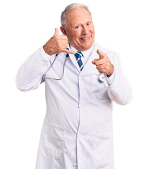 Canvas Print - Senior handsome grey-haired man wearing doctor coat and stethoscope smiling doing talking on the telephone gesture and pointing to you. call me.