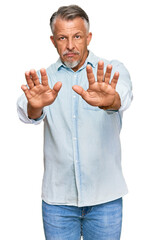 Poster - Middle age grey-haired man wearing casual clothes moving away hands palms showing refusal and denial with afraid and disgusting expression. stop and forbidden.