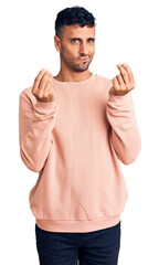 Poster - Young hispanic man wearing casual clothes doing money gesture with hands, asking for salary payment, millionaire business