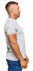 Canvas Print - Handsome muscle man wearing casual grey tshirt looking to side, relax profile pose with natural face with confident smile.