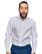 © Krakenimages.com - Young man with beard wearing business shirt afraid and shocked with surprise expression, fear and excited face.