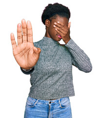 Wall Mural - Young african american girl wearing casual clothes covering eyes with hands and doing stop gesture with sad and fear expression. embarrassed and negative concept.