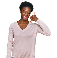 Wall Mural - Young african american girl wearing casual clothes smiling doing phone gesture with hand and fingers like talking on the telephone. communicating concepts.