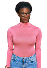 Wall Mural - Young african american girl wearing casual clothes and glasses smiling looking to the side and staring away thinking.