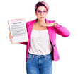 Young beautiful woman with pink hair holding clipboard with contract document cutting throat with hand as knife, threaten aggression with furious violence