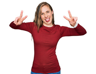 Canvas Print - Young blonde woman wearing casual clothes smiling with tongue out showing fingers of both hands doing victory sign. number two.