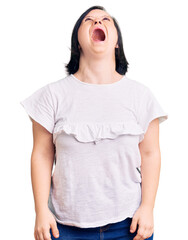 Poster - Brunette woman with down syndrome wearing casual white tshirt angry and mad screaming frustrated and furious, shouting with anger. rage and aggressive concept.