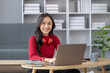 © kamiphotos - Beautiful asian woman sitting in living room, she is student doing report and homework for class, homeschooling, online learning. University student concept.