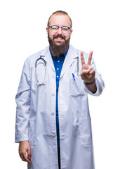 Sticker - Young caucasian doctor man wearing medical white coat over isolated background smiling with happy face winking at the camera doing victory sign. Number two.