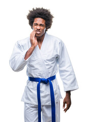 Wall Mural - Afro american man wearing karate kimono over isolated background touching mouth with hand with painful expression because of toothache or dental illness on teeth. Dentist concept.