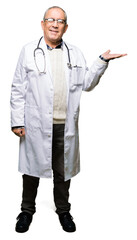 Wall Mural - Handsome senior doctor man wearing medical coat smiling cheerful presenting and pointing with palm of hand looking at the camera.