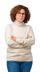 Poster - Beautiful middle ager senior woman wearing turtleneck sweater and glasses over isolated background skeptic and nervous, disapproving expression on face with crossed arms. Negative person.