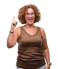 Sticker - Middle age hispanic woman wearing glasses over isolated background pointing finger up with successful idea. Exited and happy. Number one.