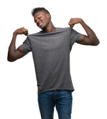 Sticker - Young african american man wearing grey t-shirt looking confident with smile on face, pointing oneself with fingers proud and happy.