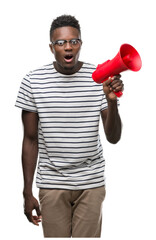 Wall Mural - Young african american man holding megaphone scared in shock with a surprise face, afraid and excited with fear expression