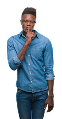 Poster - Young african american man over isolated background asking to be quiet with finger on lips. Silence and secret concept.