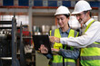 © Nassorn - Industrial engineer and colleague wear safety helmets examining production in heavy metal engineering factories. Beard man industry inspector inspecting metalwork in manufacturing warehouse facility.