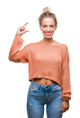 Poster - Beautiful young blonde woman over isolated background smiling and confident gesturing with hand doing size sign with fingers while looking and the camera. Measure concept.