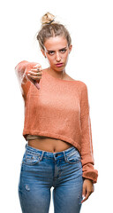 Sticker - Beautiful young blonde woman over isolated background looking unhappy and angry showing rejection and negative with thumbs down gesture. Bad expression.