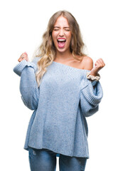 Poster - Beautiful young blonde woman wearing winter sweater over isolated background excited for success with arms raised celebrating victory smiling. Winner concept.