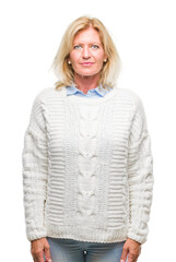 Poster - Middle age blonde woman wearing winter sweater over isolated background with serious expression on face. Simple and natural looking at the camera.