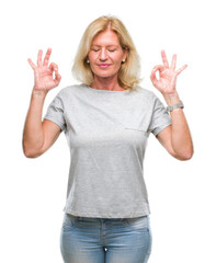 Sticker - Middle age blonde woman over isolated background relax and smiling with eyes closed doing meditation gesture with fingers. Yoga concept.