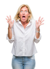 Canvas Print - Middle age blonde business woman over isolated background crazy and mad shouting and yelling with aggressive expression and arms raised. Frustration concept.