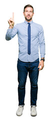 Wall Mural - Handsome business man wearing tie showing and pointing up with finger number one while smiling confident and happy.