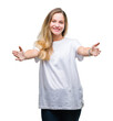 © Krakenimages.com - Young beautiful blonde woman wearing casual white t-shirt over isolated background looking at the camera smiling with open arms for hug. Cheerful expression embracing happiness.