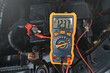 Multimeter checking car battery voltage level. Check car battery using voltmeter. Man check up voltage level, alternator produce 12.3 volts with the engine idling. Winter service maintenance