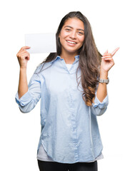 Poster - Young arab woman holding blank card over isolated background very happy pointing with hand and finger to the side