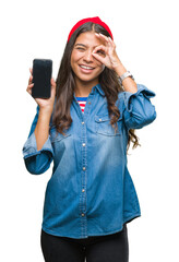 Canvas Print - Young beautiful arab woman showing screen of smartphone over isolated background with happy face smiling doing ok sign with hand on eye looking through fingers