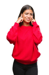 Poster - Young beautiful arab woman wearing winter sweater over isolated background covering ears with fingers with annoyed expression for the noise of loud music. Deaf concept.