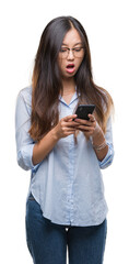 Wall Mural - Young asian woman texting using smartphone over isolated background scared in shock with a surprise face, afraid and excited with fear expression