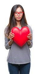 Sticker - Young asian woman in love holding read heart over isolated background with a confident expression on smart face thinking serious