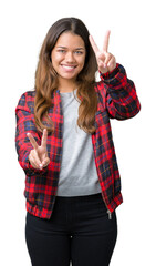 Sticker - Young beautiful brunette woman wearing a jacket over isolated background smiling looking to the camera showing fingers doing victory sign. Number two.