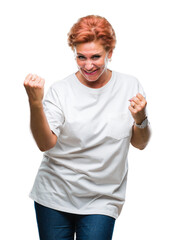 Sticker - Atrractive senior caucasian redhead woman over isolated background very happy and excited doing winner gesture with arms raised, smiling and screaming for success. Celebration concept.