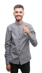 Wall Mural - Young hipster man doing happy thumbs up gesture with hand. Approving expression looking at the camera with showing success.