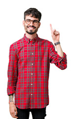 Sticker - Young handsome man wearing glasses over isolated background showing and pointing up with finger number one while smiling confident and happy.