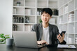 © Nuttapong punna - Young business man working at modern office with laptop, tablet and taking notes on the paper..