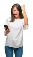 Wall Mural - Young asian woman texting using smartphone over isolated background annoyed and frustrated shouting with anger, crazy and yelling with raised hand, anger concept