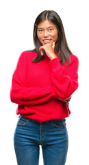 Sticker - Young asian woman wearing winter sweater over isolated background looking confident at the camera with smile with crossed arms and hand raised on chin. Thinking positive.