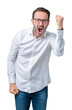 © Krakenimages.com - Handsome middle age elegant senior business man wearing glasses over isolated background angry and mad raising fist frustrated and furious while shouting with anger. Rage and aggressive concept.