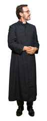 Sticker - Middle age priest man wearing catholic robe smiling looking to the side with arms crossed convinced and confident