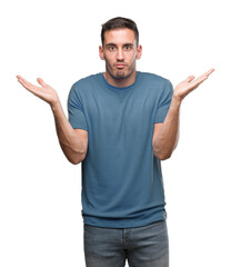 Canvas Print - Handsome young casual man clueless and confused expression with arms and hands raised. Doubt concept.