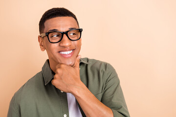 Poster - Portrait of minded intelligent man hand touch chin toothy smile look empty space isolated on beige color background