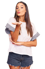 Wall Mural - Young hispanic woman wearing casual clothes looking at the camera blowing a kiss with hand on air being lovely and sexy. love expression.